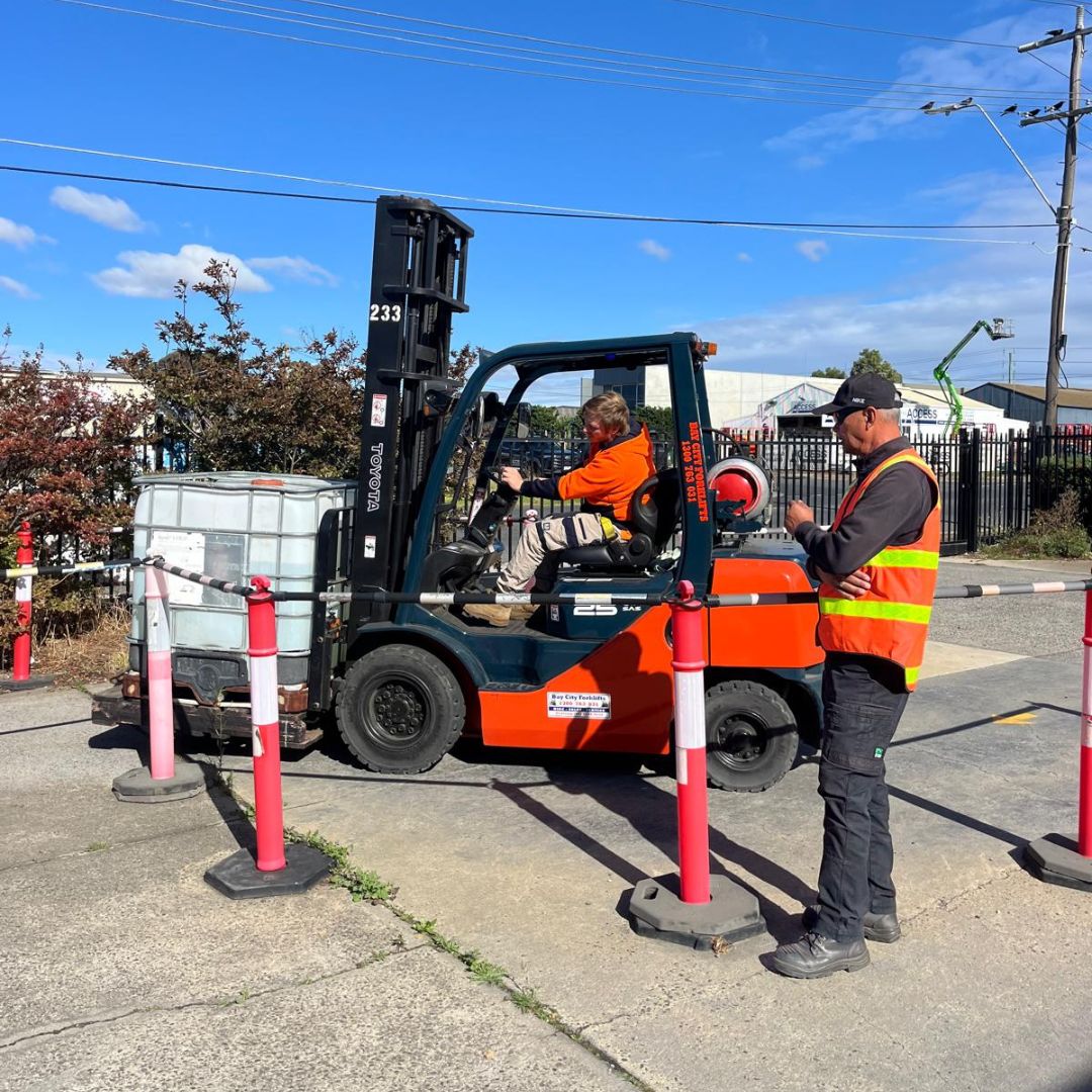 A trainee operating a Toyota forklift at the North Geelong training facility while Guy supervises.